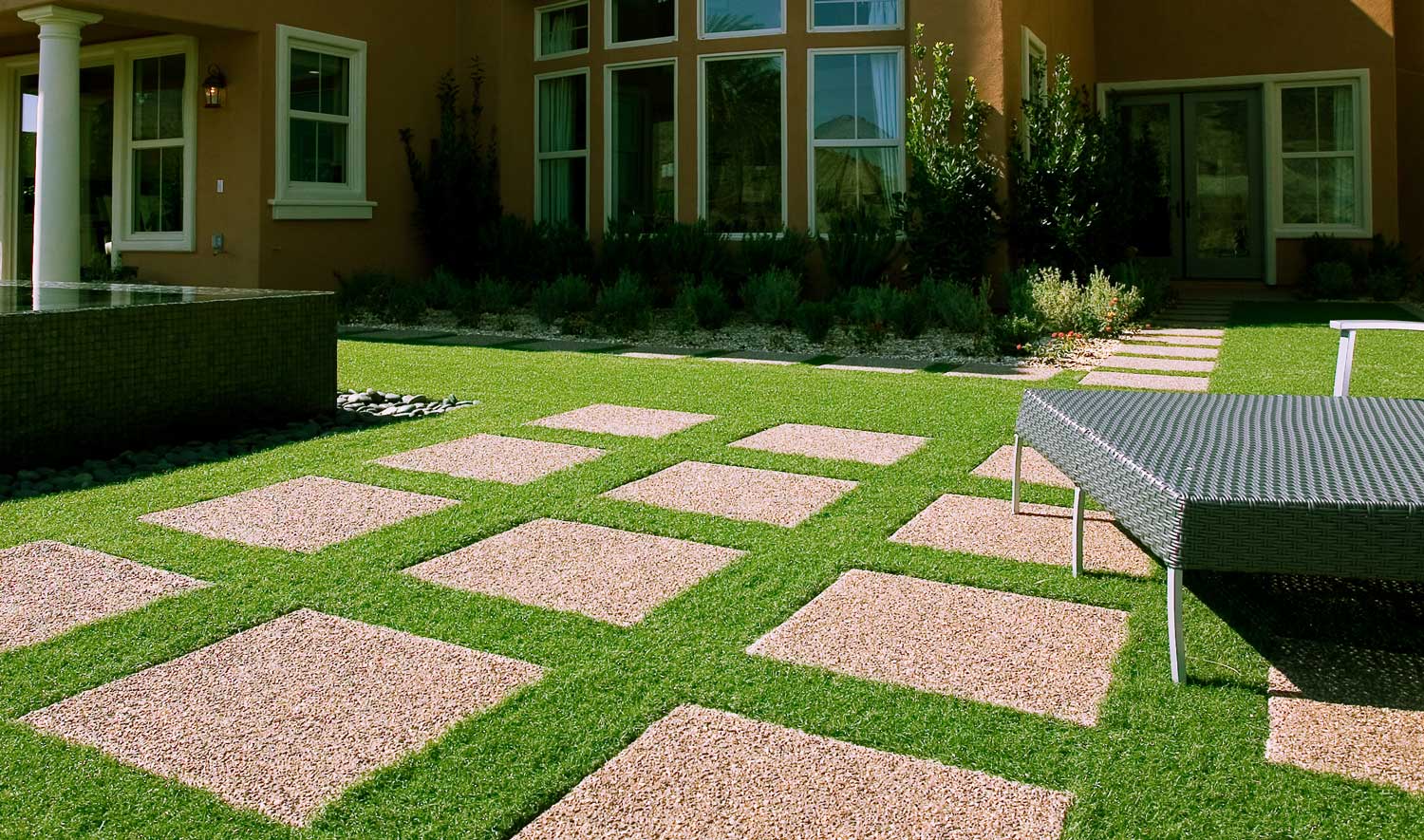 image of artificial grass with large square pavers in backyard